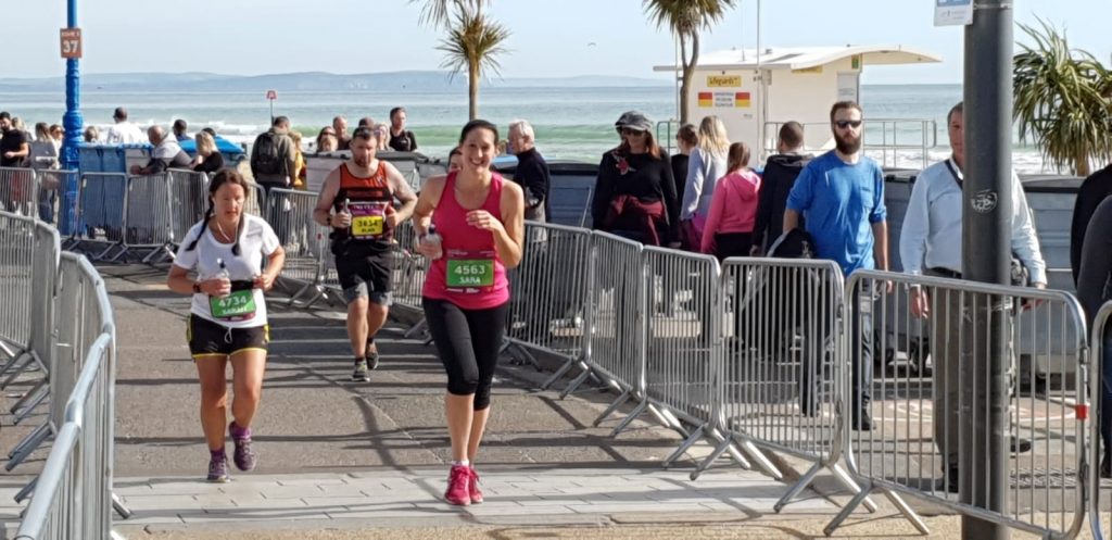 Sara running the bournemouth marathon towards bournemouth pier