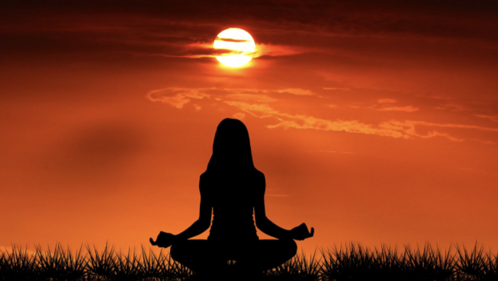 30 Days of Yoga - silhouette of woman meditating