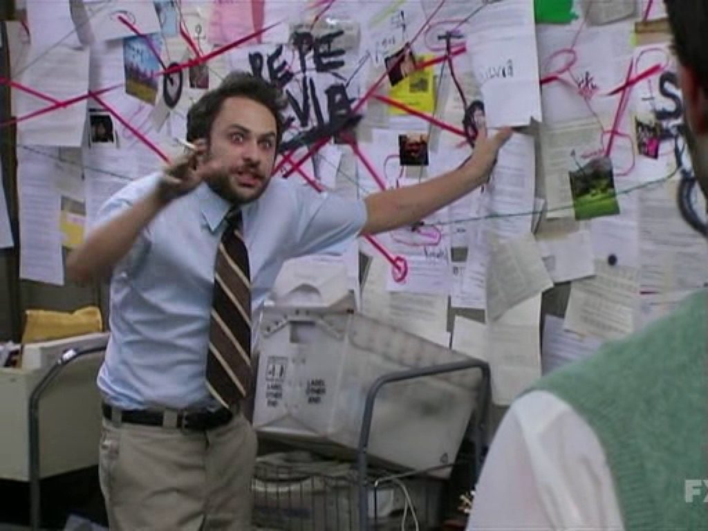 Man in front of mind map board with crazy look in his eyes