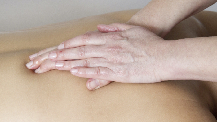 Massage for back pain - hands massaging someone's back